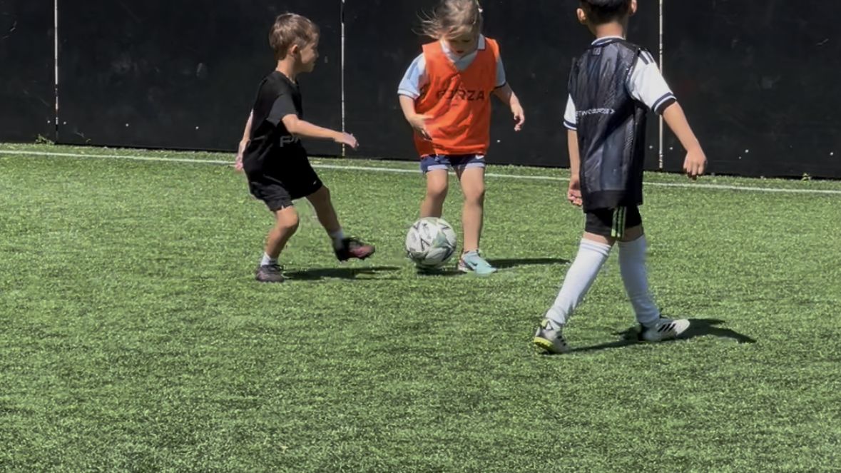 Children dribbling through cones at a Fun Football Way session